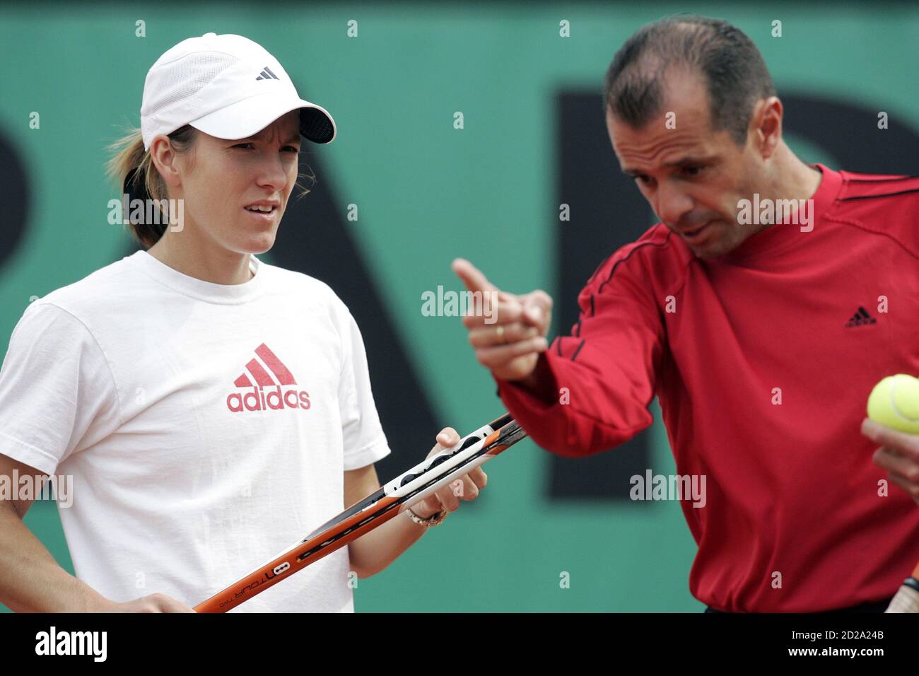 Justine Henin-Hardenne (L) of Belgium listens to her coach Carlos Rodriguez  during a training session ahead of the French Open tennis tournament at the  Roland Garros stadium in Paris, May 26, 2006.