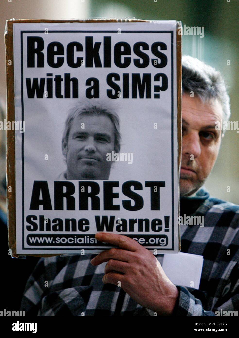 A man with sign that refers to Australian cricketer Shane Warne, protests in support of Indian doctor Mohamed Haneef, outside the Department of Immigration and Citizenship offices in Sydney July 18,