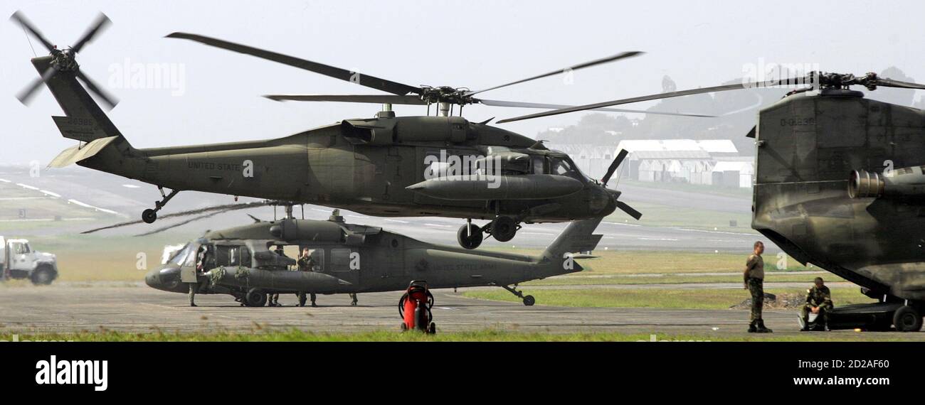 U.S. army soldiers stand near military helicopters with relief supplies bound for flood victims at an airport in Guatemala City October 11, 2005. Maya Indian villagers gave up hope on Monday of finding up to 1,400 victims buried in a huge mudslide in Guatemala even as sniffer dogs led a final, almost certainly futile search for miracle survivors. REUTERS/Daniel Aguilar Stock Photo