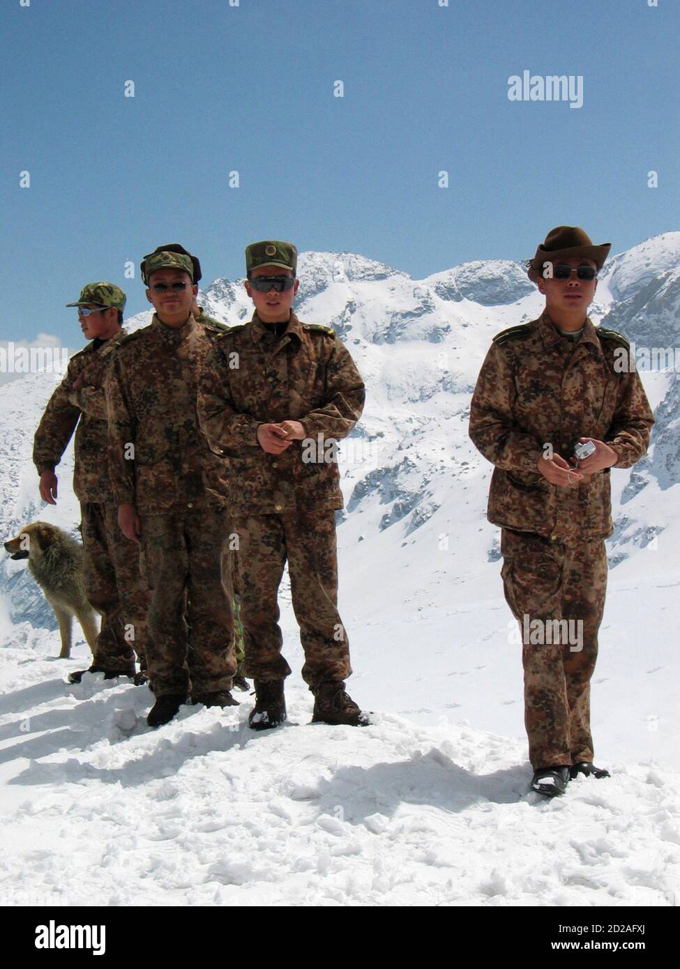 Chinese soldiers walk on snow at the 4,310 metre high Nathu-la pass on the country's northeastern border with China in this April 9, 2005 file photo. Just a few yards away bulldozers on both sides of the frontline are building not fortifications but a road, to connect India and China and reopen a historic trade route. New Delhi and Beijing plan to reopen the Nathu-la pass in June after more than 40 years, a potent symbol of rapprochement between Asian giants who fought a Himalayan war in 1962. Picture taken April 9, 2005. To match feature INDIA CHINA TRADE. REUTERS/Rupak De Chowdhuri (INDIA) Stock Photo