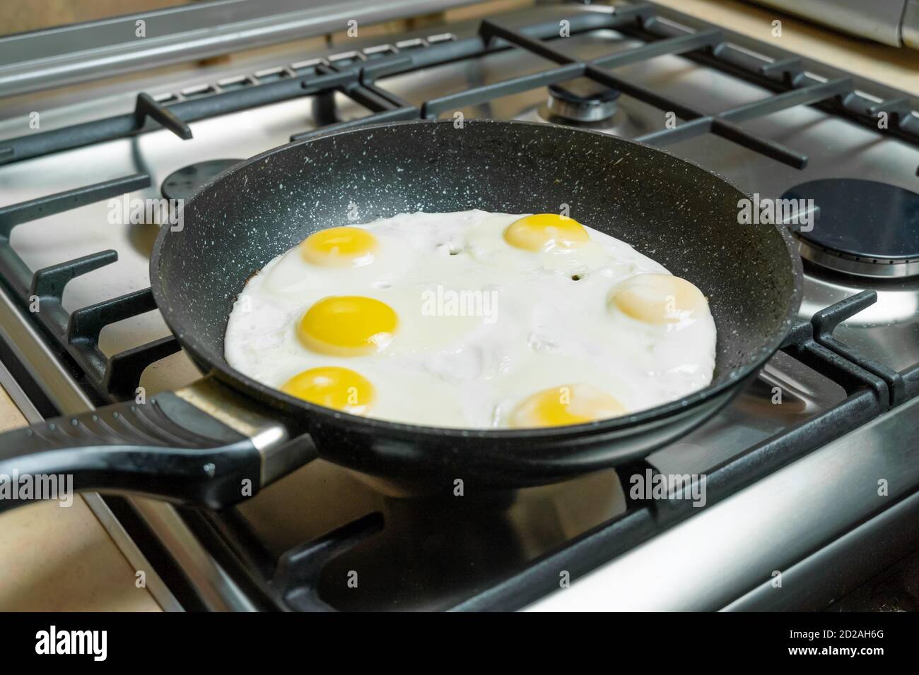Six eggs in closeup frying in a pan on a gas stove Stock Photo Alamy