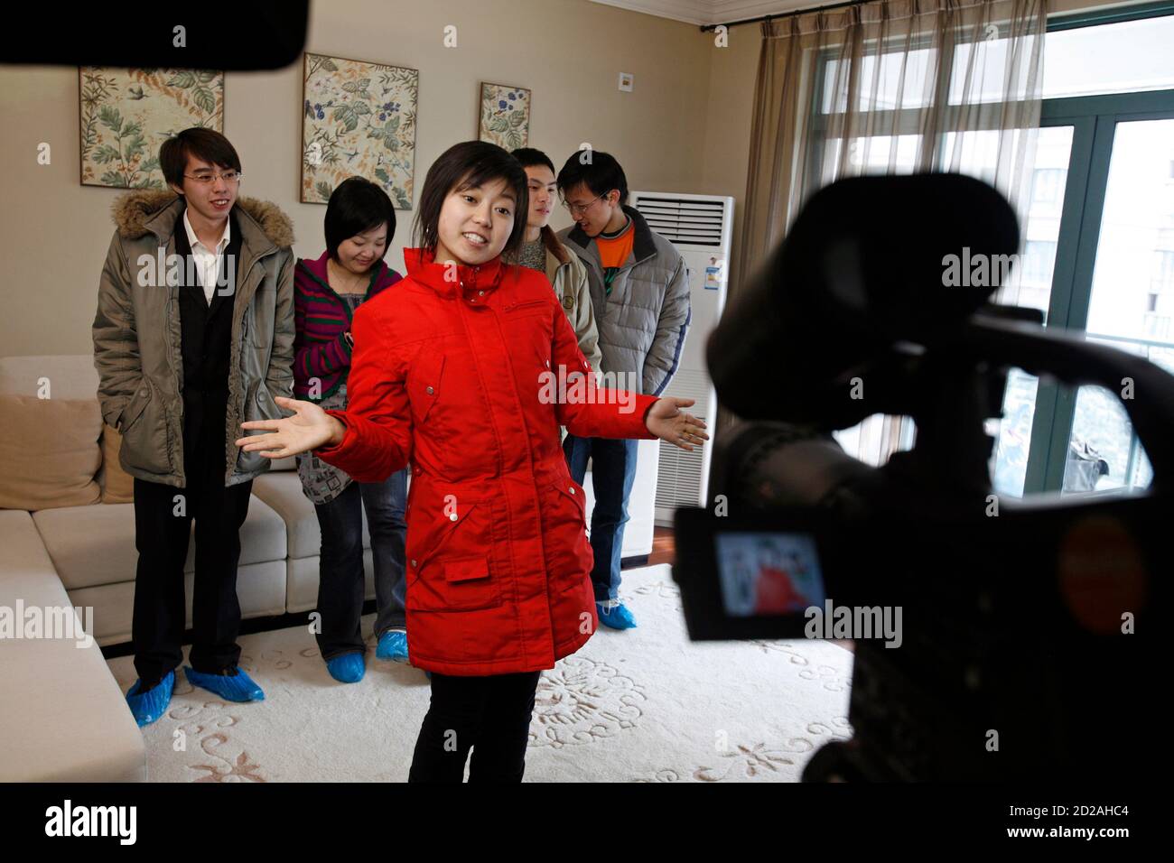 Amateur actors pose in front of the camera on the set of 'Soul Partners', a new comedy series described as China's version of the U.S. TV hit 'Friends', in an apartment in Songjiang New Town, about 30 km (18 miles) from Shanghai February 4, 2007. 'Soul Partners' features six people in their 20s who live together after being separately tricked into buying the same apartment. To match feature INTERNET-CHINA/FRIENDS  REUTERS/Nir Elias (CHINA) Stock Photo