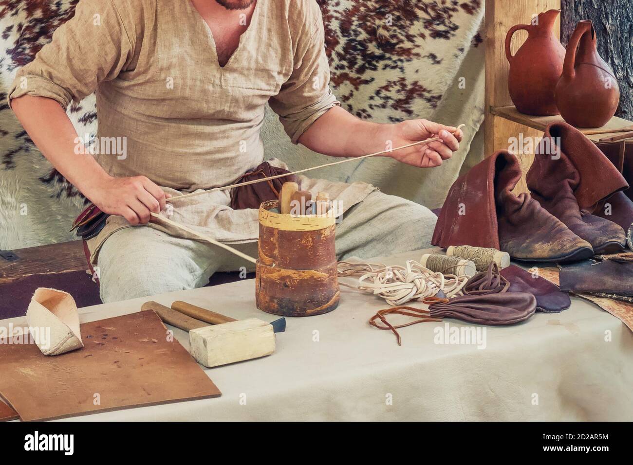 Shoemaker in a retro repairs boots. A craftsman in a shoe shop makes shoes Stock Photo