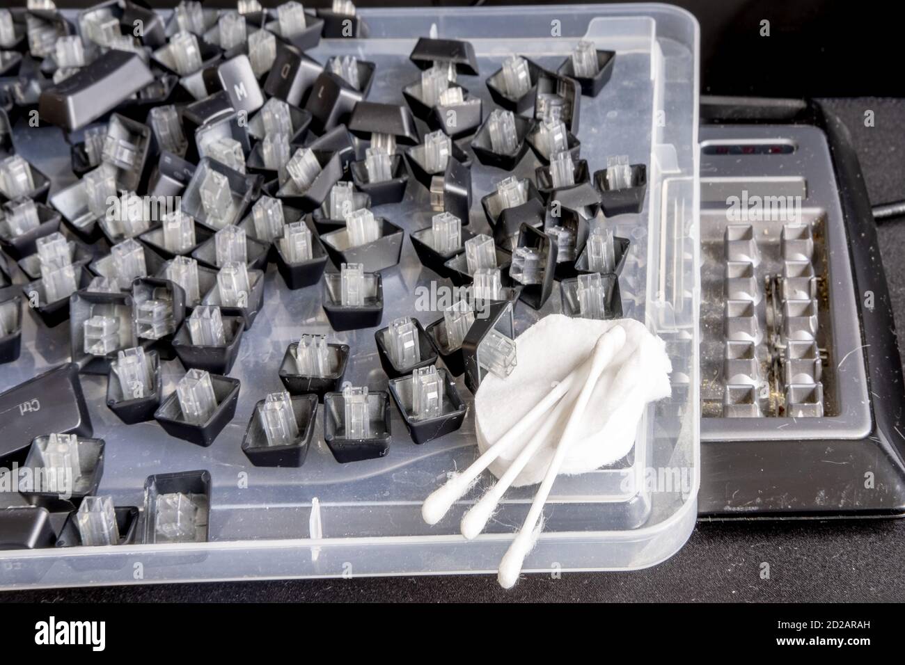 Cleaning the keys of a dirty keyboard with rubbish with cotton swabs