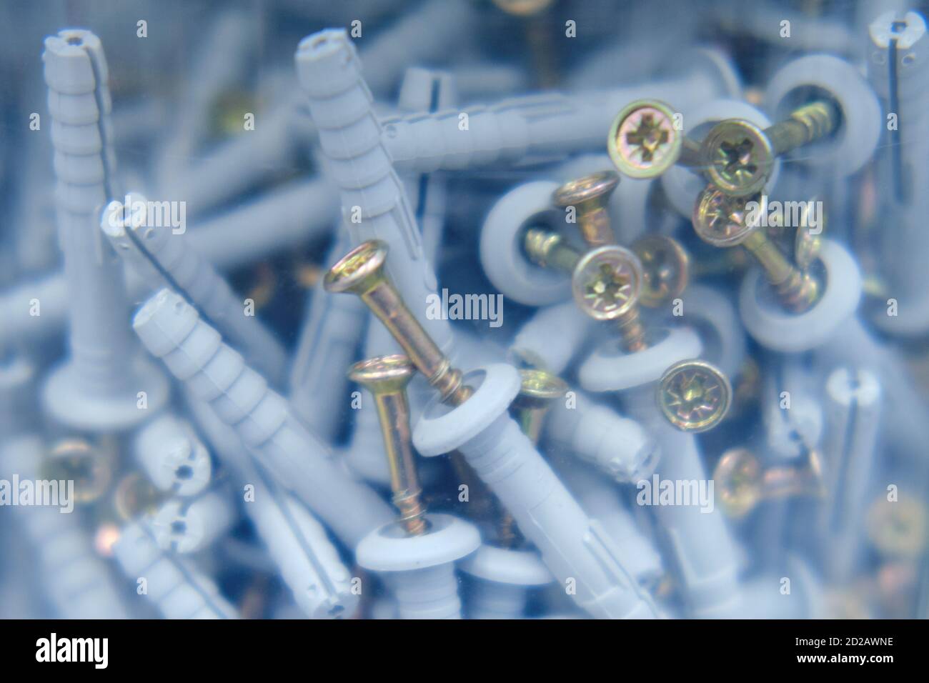 Screws with dowels in a plastic jar, close-up background Stock Photo