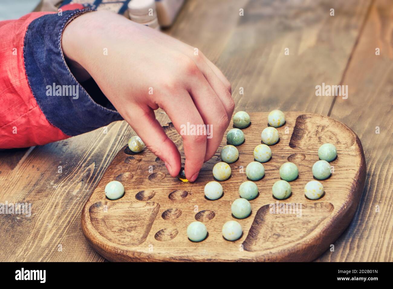 A man plays a retro board game Mill. An old intellectual game for two players. Stock Photo
