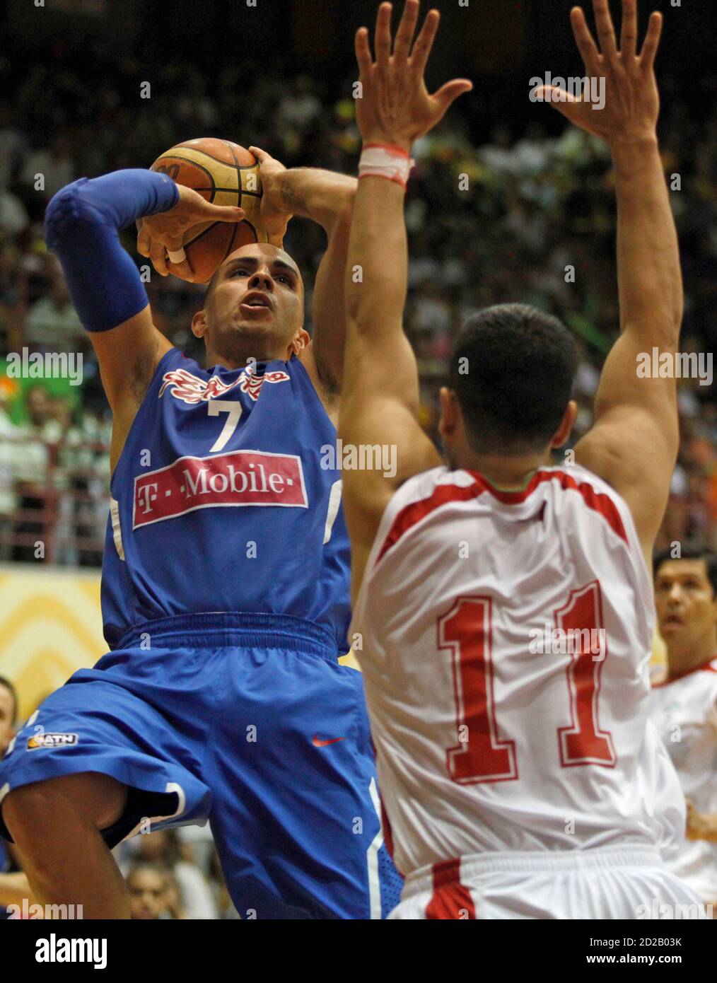 Carlos Arroyo of Puerto Rico goes for the basket against Omar Quintero (R)  of Mexico during their men's basketball final at the Central American and Caribbean  Games in Mayaguez, July 30, 2010.