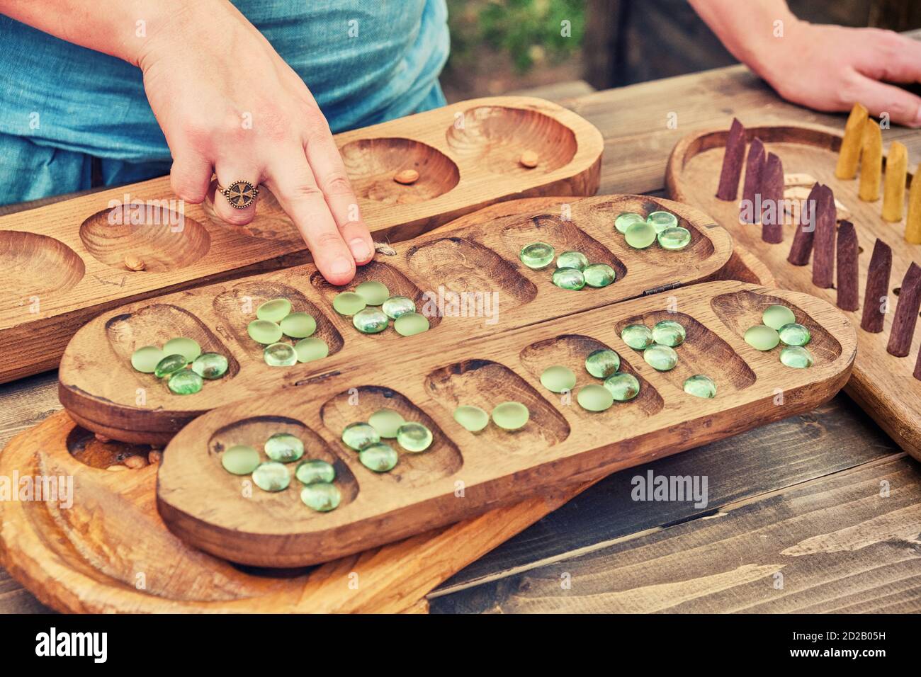 Vari (Ovare) is a board logic game for two from the family of mancala games. People play an ancient board game of the Mancala, Kalah. Stock Photo