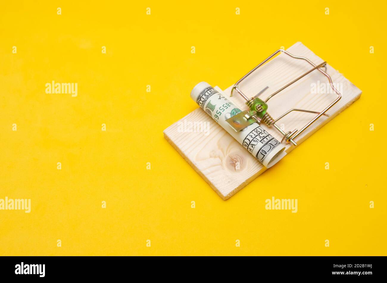 https://c8.alamy.com/comp/2D2B1WJ/dollars-in-a-mousetrap-with-a-hundred-dollar-bill-on-a-yellow-background-with-a-copy-space-2D2B1WJ.jpg