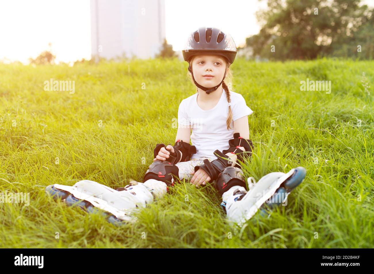 Pretty little girl learning to roller skate at the park Stock Photo