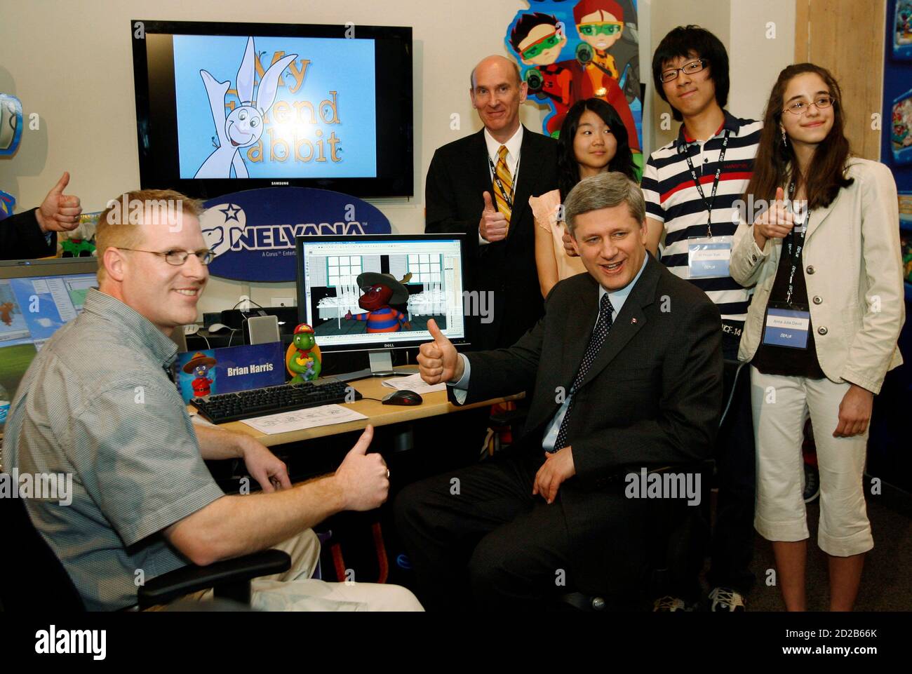 Canada's Prime Minister Stephen Harper (seated R) poses with Nelvana Animation Supervisor Brian Harris (L), General Manager Scott Dyer (rear) and students from Althouse Middle School before touring the Nelvana Studio in Toronto April 18, 2008. REUTERS/ Mike Cassese   (CANADA) Stock Photo