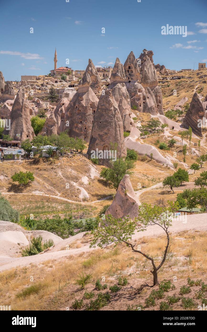 Scenic view of Uchisar castle with rock formations, caves, rock buildings and trees Stock Photo