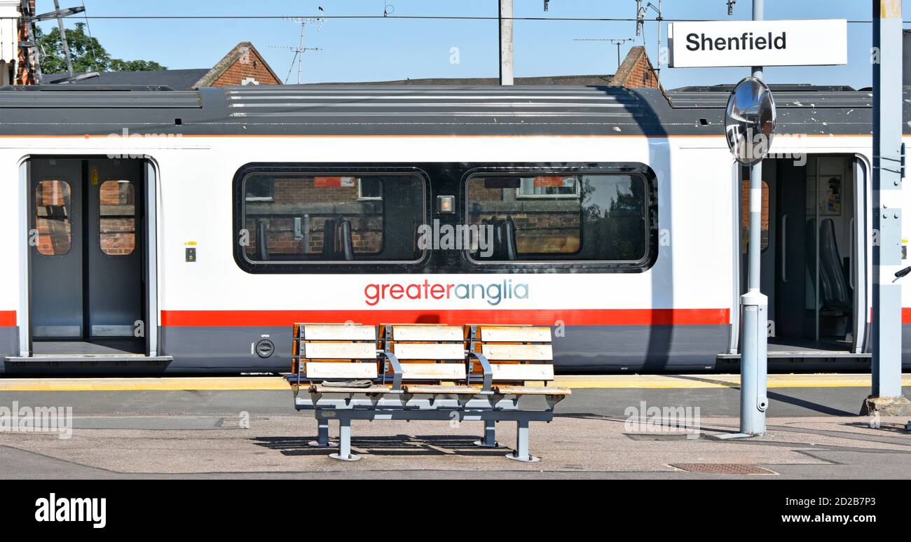 Side view of stationary public transport Greater Anglia passenger train carriage waiting at Shenfield station railway platform with door open Essex UK Stock Photo