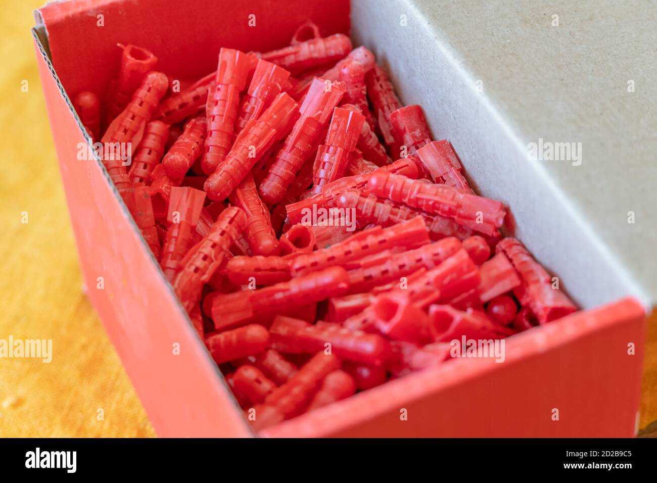 red dowels in a red cardboard box close up Stock Photo