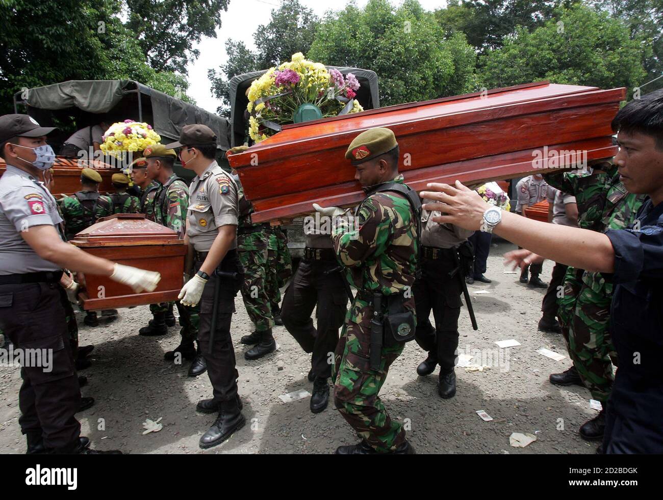 Indonesian soldiers and police carry coffins of unidentified bodies outside a morgue at a hospital in Medan, Indonesia, September 7, 2005. A preliminary probe into the crash of an Indonesian airliner that killed 149 people has found a fuel problem with one of the plane's engines, a transport safety official said on Wednesday. Authorities prepared a mass funeral for 57 victims whose bodies were too charred to identify. They will be buried in a field on Wednesday where the remains of victims from two previous air crashes near Indonesia's third biggest city also lie. REUTERS/Supri  supri/PN Stock Photo