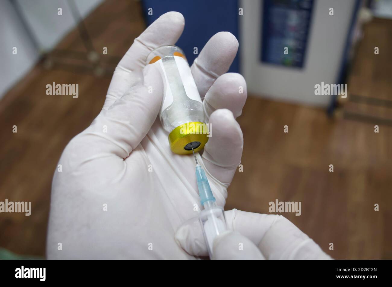 Doctor filling syringe with medication, closeup. Visible hands in white