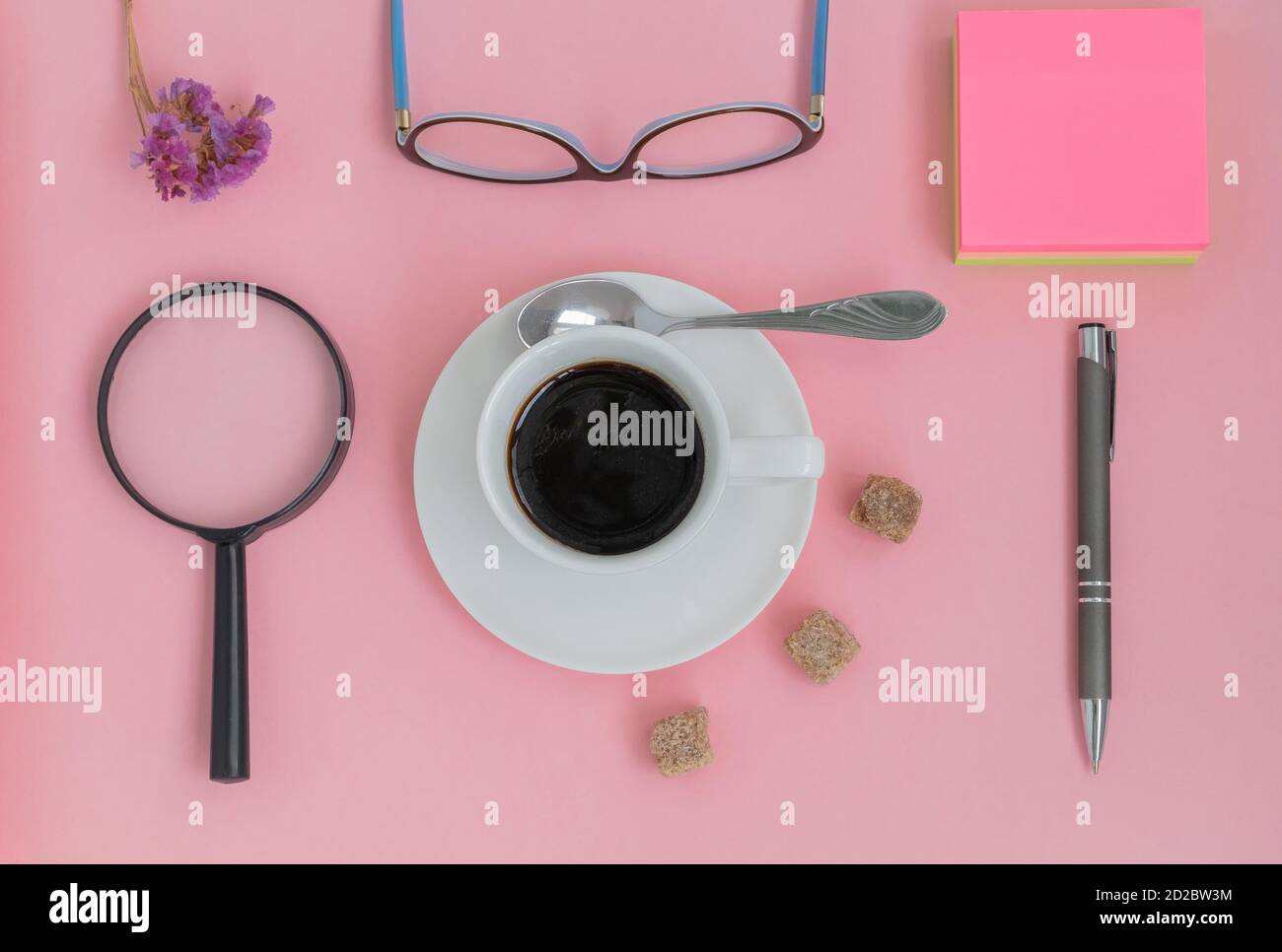 View from the top of a set of items with a cup of coffee on a pink background Stock Photo