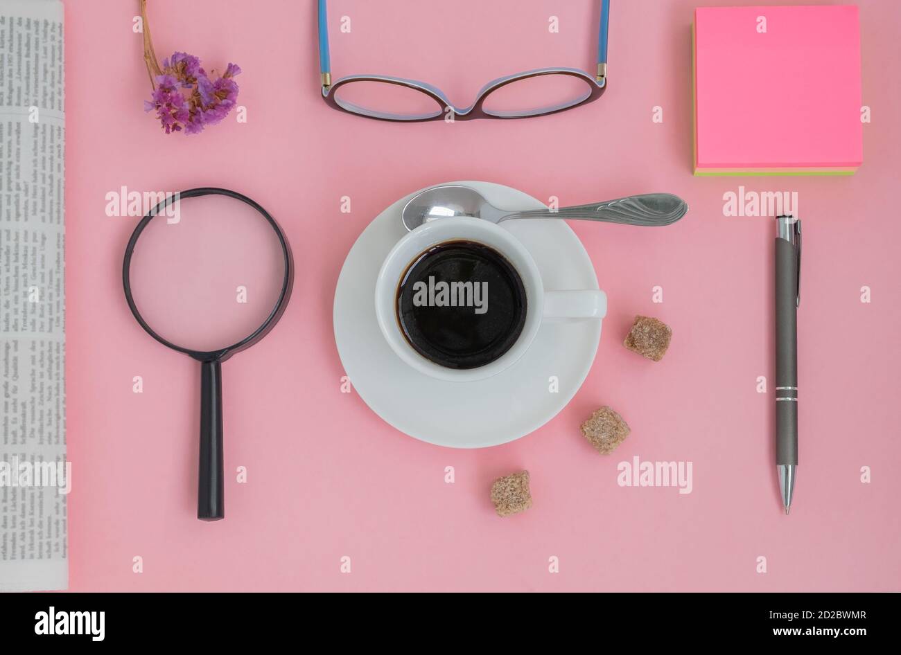 Close up of a set of items with a cup of coffee on a pink background Stock Photo