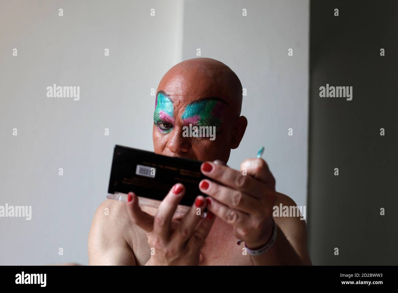 Alfredo Baez, a drag queen, checks his makeup at his apartment in  preparation for a Gay Pride parade in Monterrey June 12, 2010. The gay  rights activist joined other gay men, lesbians,