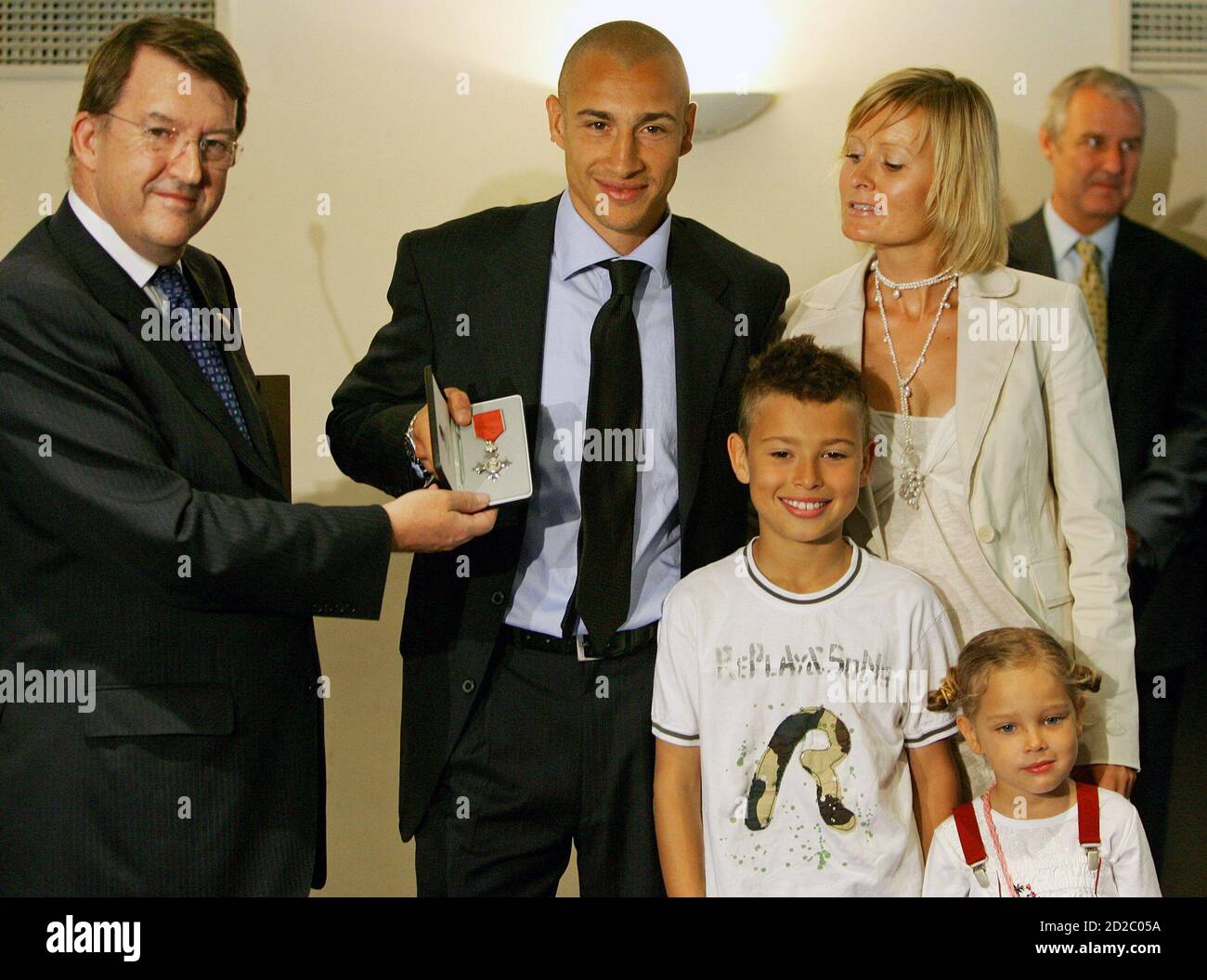 Barcelona's Henrik Larsson (C) from Sweden receives the Member of the Order  of the British Empire (MBE) medal from British ambassador to Spain Stephen  Wright (L) together with his wife Magdalena (2nd