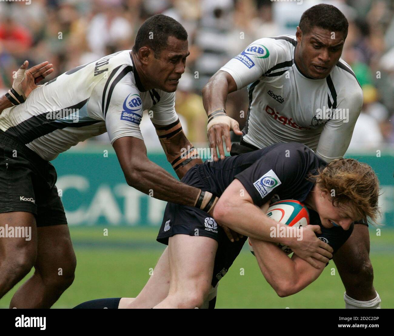 Scotland's Simon Cross (bottom) is tackled by Fiji's Mosese Volavola (L) and Etonia Naba during their Cup quarter-final match at the Hong Kong Sevens rugby tournament in Hong Kong April 1, 2007.      REUTERS/Bobby Yip  (CHINA) Stock Photo