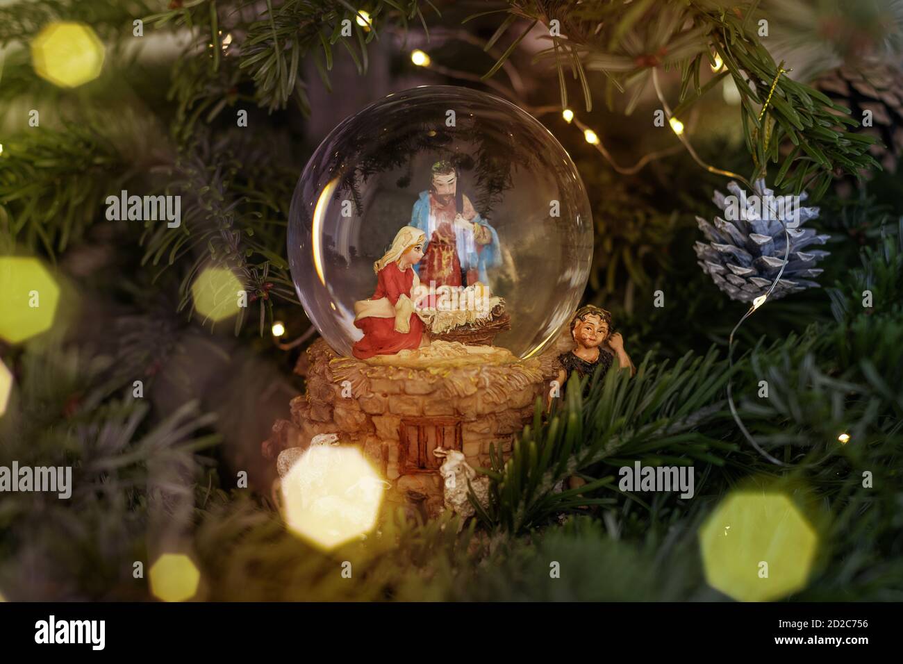 Scene of the birth of Jesus Christ in a glass ball on a Christmas tree ...