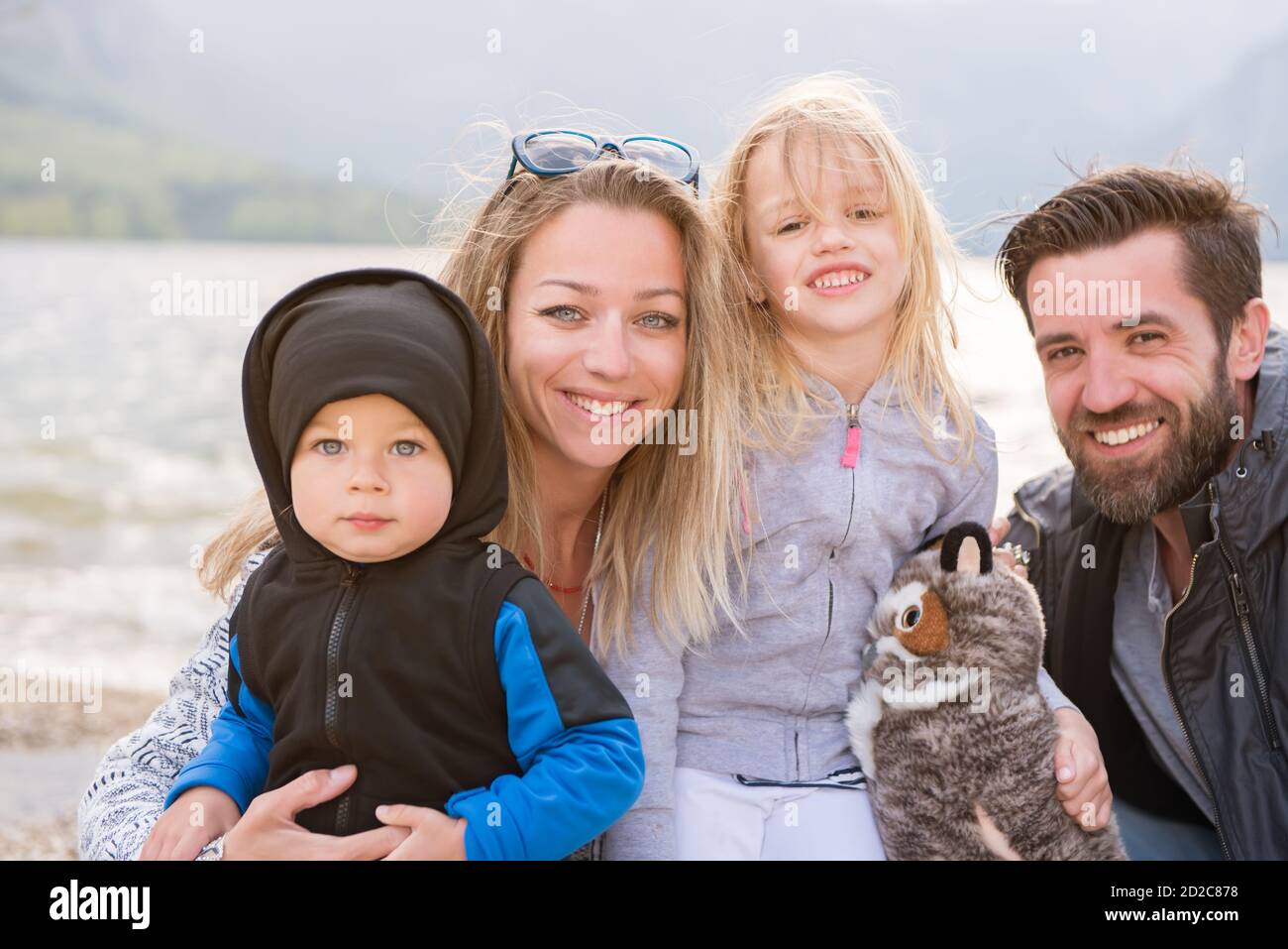 Portrait of happy family near the lake on a sunny day Stock Photo