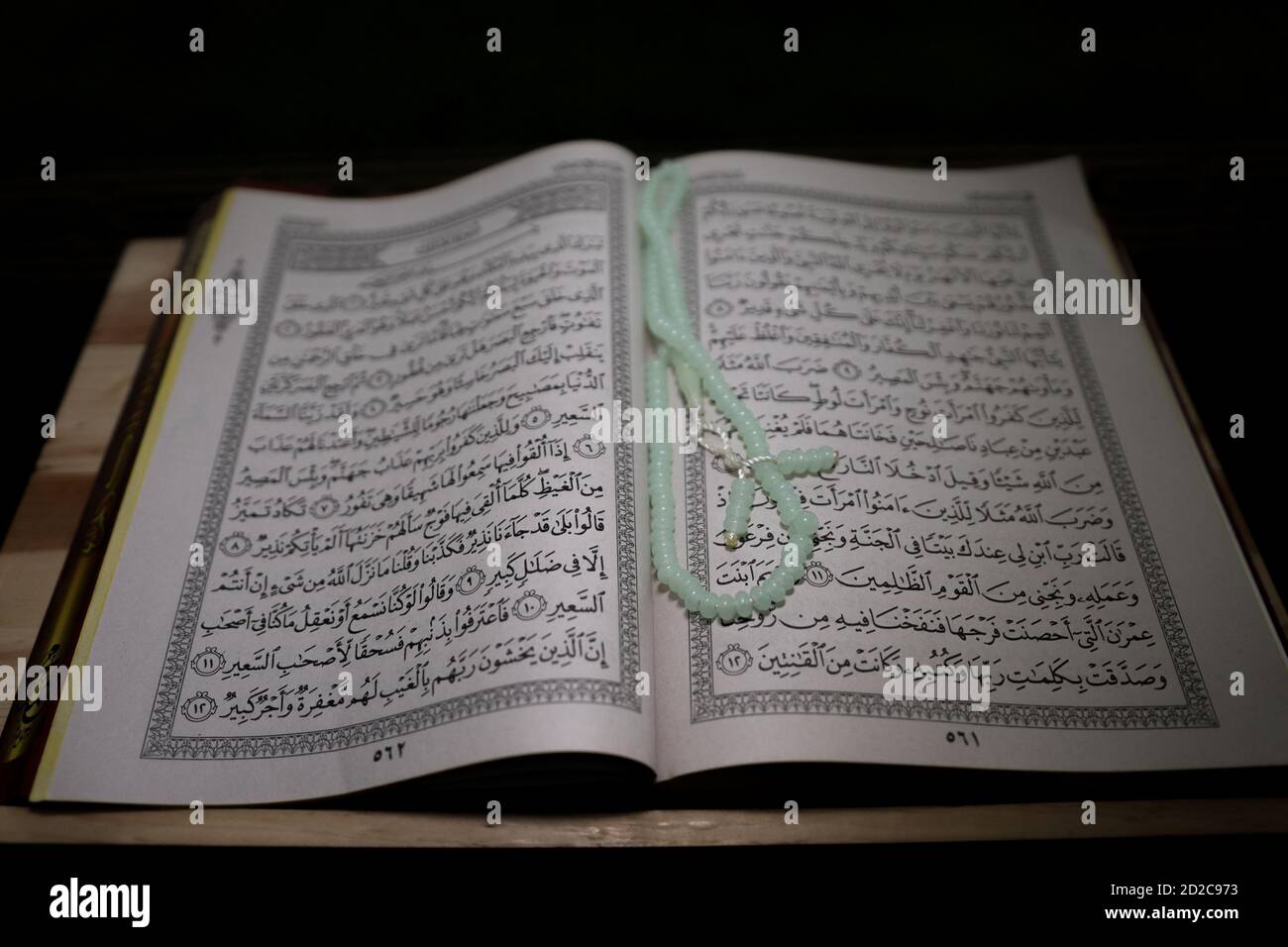 al-Quran is a holy book of Islamic guidance isolated. religion concept. An open page of Quran on wooden stand above the prayer mat open page of Quran Stock Photo