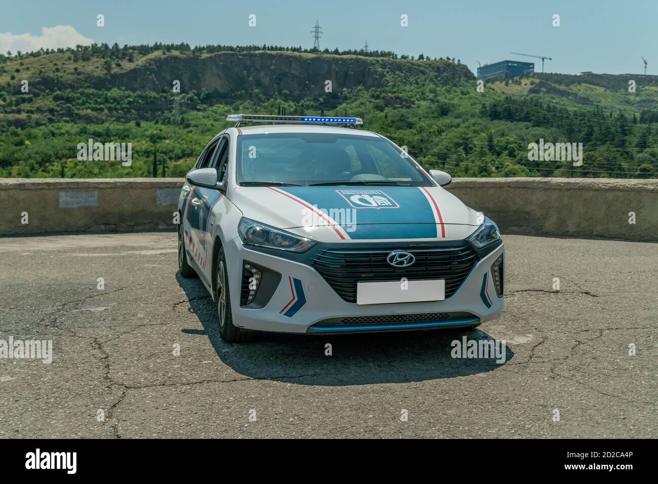 Tbilisi, Georgia - June 28 2019: Police car on an asphalt road against the mountains on a sunny clear day Stock Photo