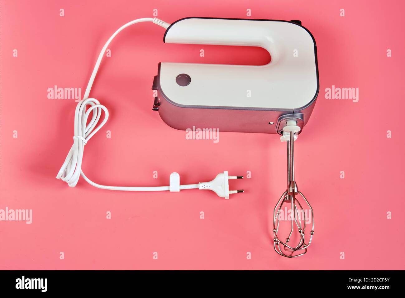 Hand electric blender with whisks on a red background, closeup Stock