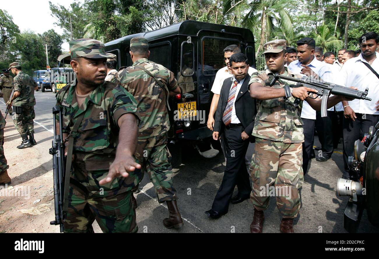 Eastern Province Chief Minister and former Tamil rebel Pillayan (C) is  escorted by army commandos as he walks to the scene of a shooting in  Athurugiriya, a suburb of Colombo November 14,