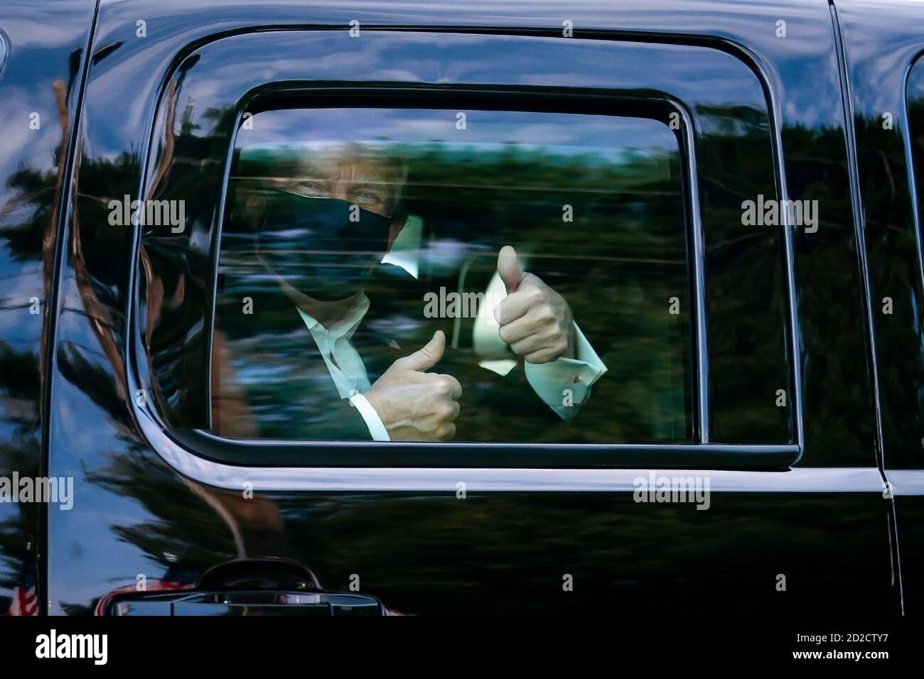 President Donald J. Trump, after being treated for COVID-19, greets supporters during a drive by outside of Walter Reed National Military Medical Center Sunday, October 4, 2020, in Bethesda, Maryland. (USA) Stock Photo
