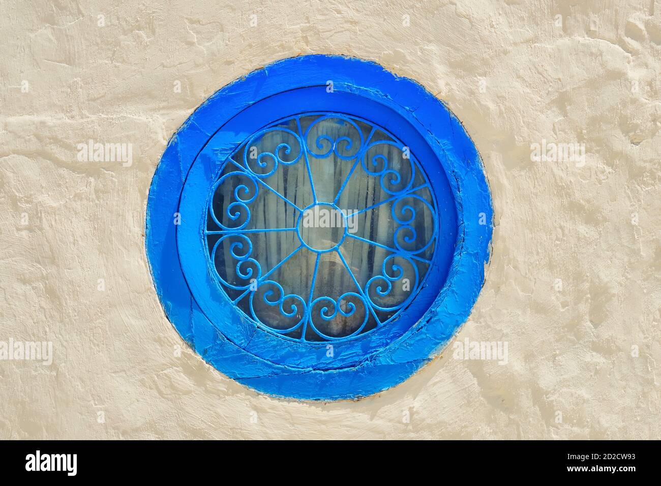 Round blue window and bar with arabic pattern . Wall of a house in Sidi ...