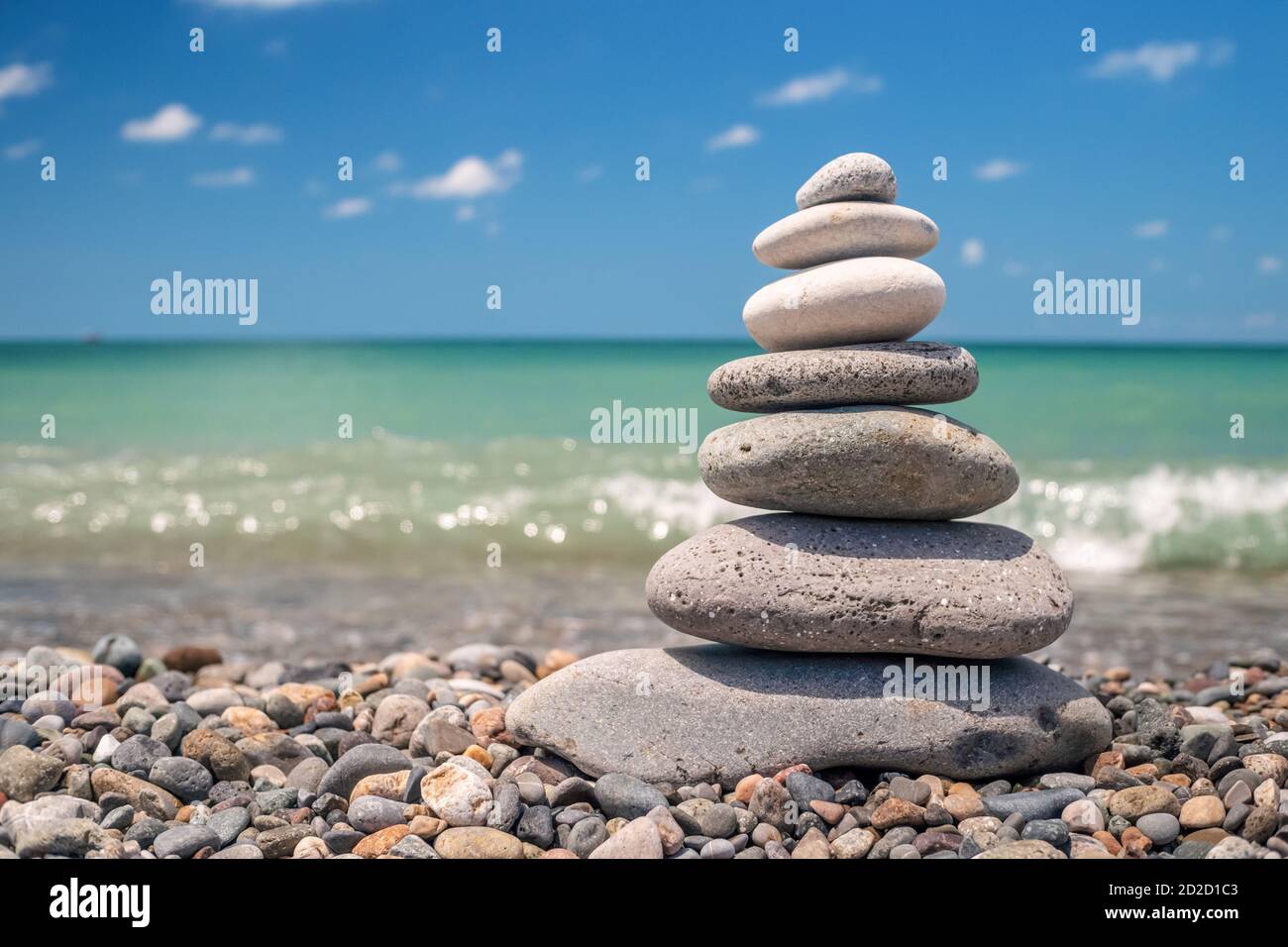 pyramid of sea pebbles on the beach against the backdrop of the sea ...