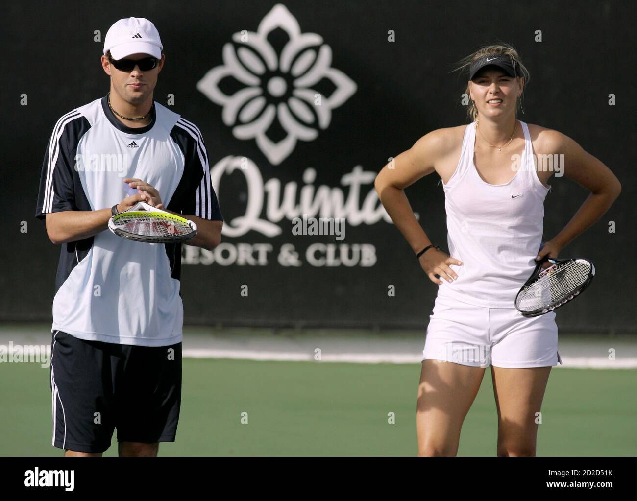 Maria Sharapova (R) and Bob Bryan stand on the court prior to playing in an  exhibition mixed-doubles tennis match during the Duel in the Desert to  benefit the National Junior Tennis League