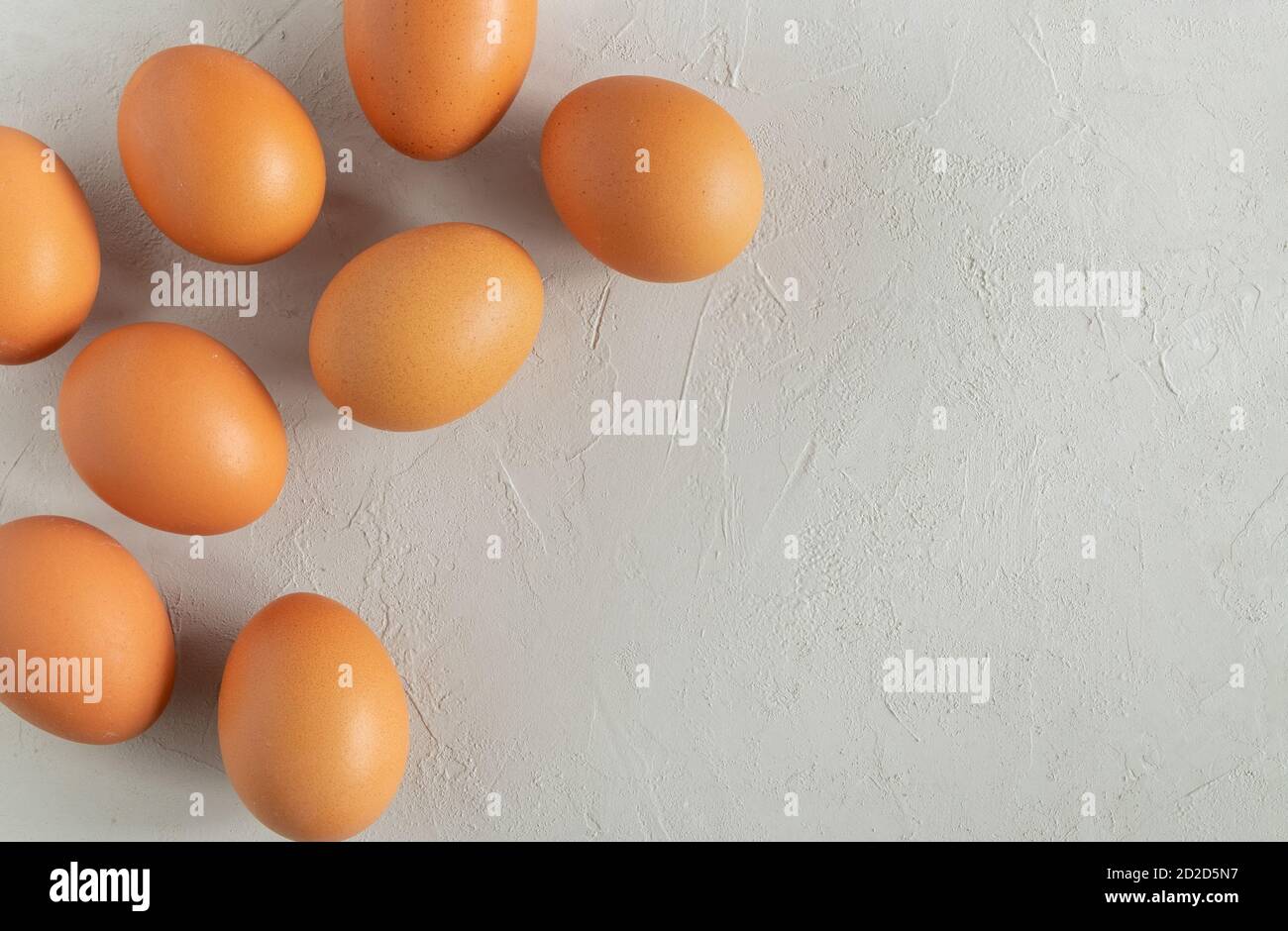 Fresh chicken eggs on a grey surface. Stock Photo