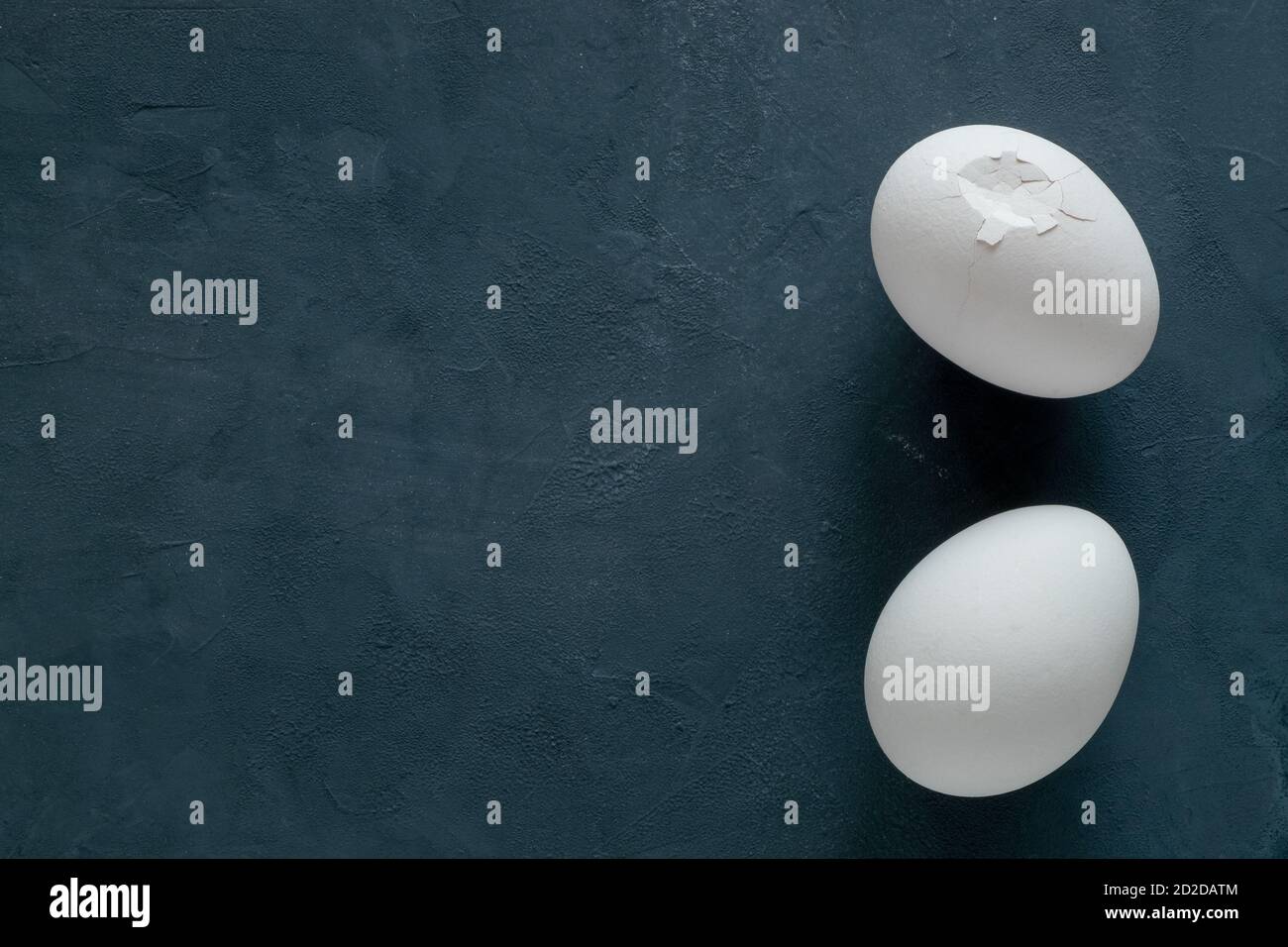 Two white broken chicken eggs on a black background Stock Photo