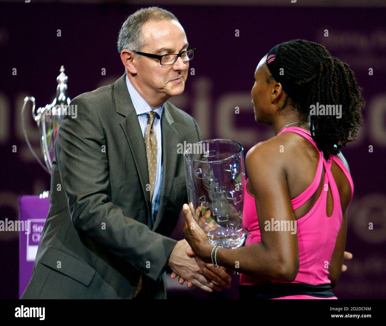 Venus Williams of the U.S. receives the runner-up trophy from Aldo Liguori  of Sony Ericsson after the WTA Tour Championships final tennis match  against her sister Serena Williams, in Doha November 1,