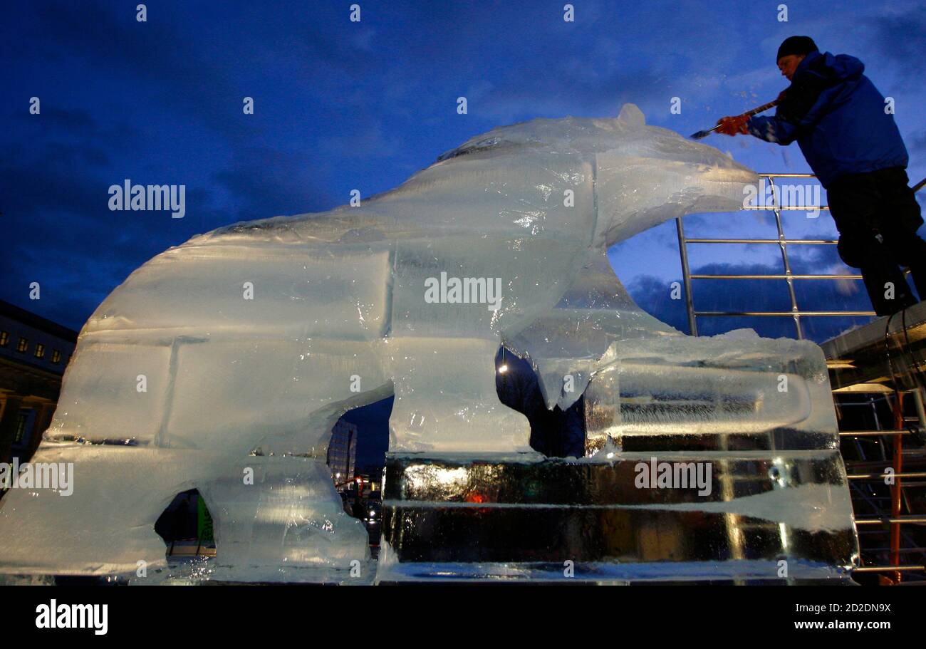 German ice sculpture artist Christian Funk, carves a polar bear out of 15 tons of ice near the Brandenburg Gate in Berlin, in Berlin December 7, 2007. According to Greenpeace, the ice sculpture is a memorial for climate protection. The sculpture is four meters high, four meters long and 1,5 meters wide. REUTERS/Johannes Eisele (GERMANY) Stock Photo