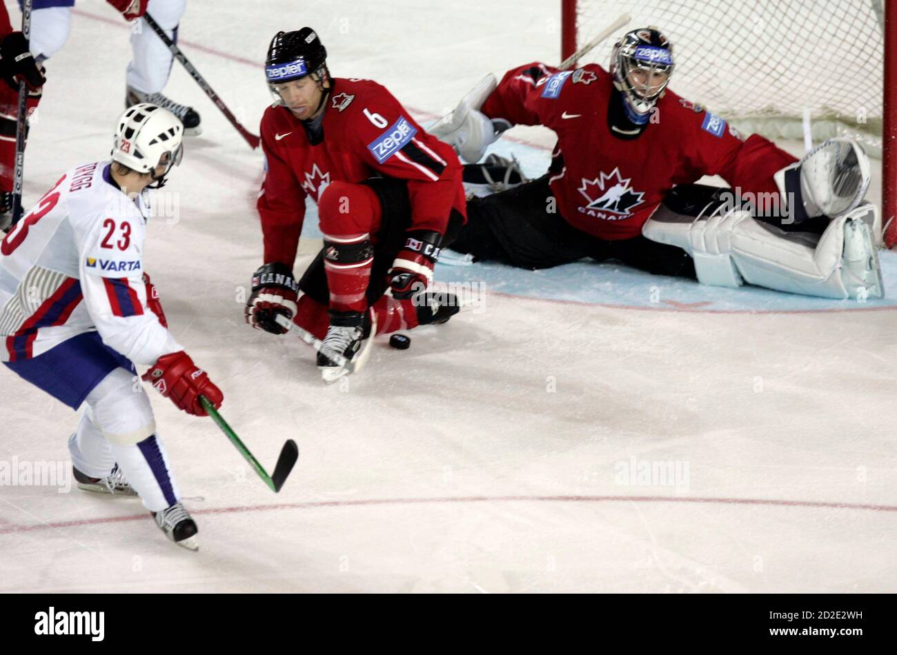 Canada's goal tender Alex Auld (R) is helped to save a puck shot from  Norway's Mats Trygg (23) while defender Brad Stuart (C) tries to assist  during their Group D preliminary ice