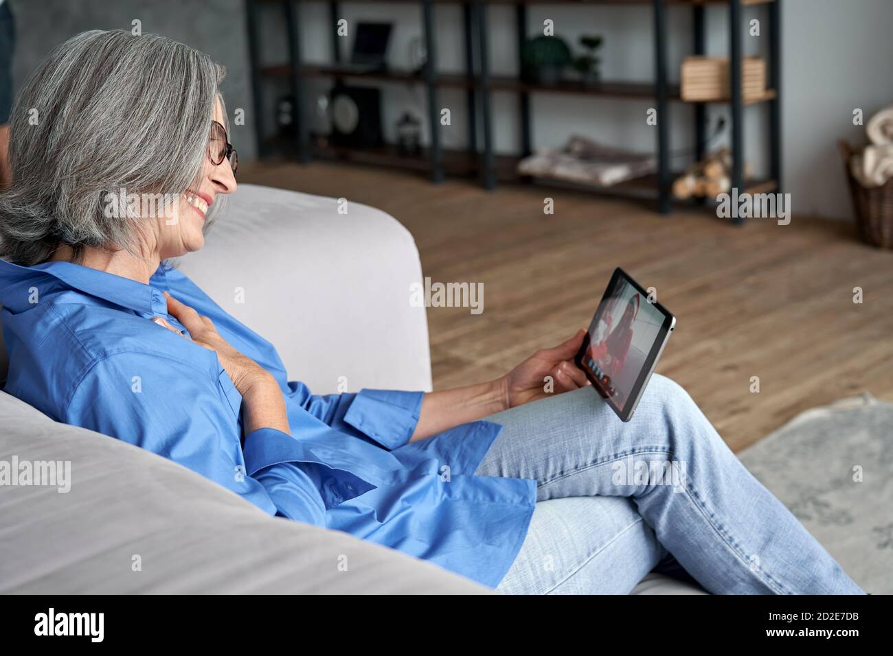 Happy senior old grandmother video calling granddaughter on Christmas. Stock Photo