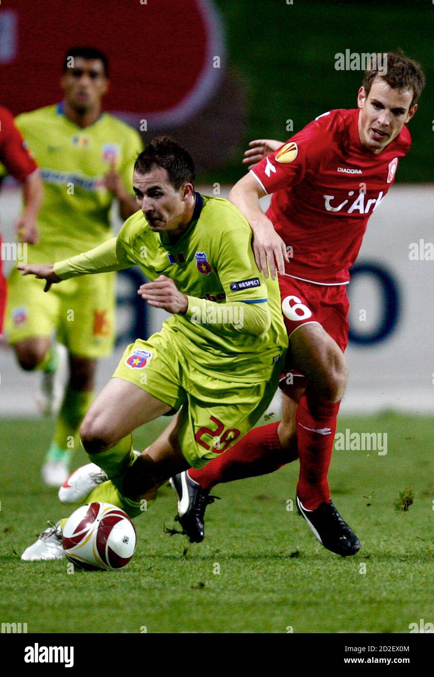 Twente Enschede's Wout Brama (R) fights for the ball with Steaua  Bucharest's Bogdan Stancu UEFA Europa League soccer match at the Arke  Stadium in Enschede October 1, 2009. REUTERS/Jerry Lampen (NETHERLANDS SPORT