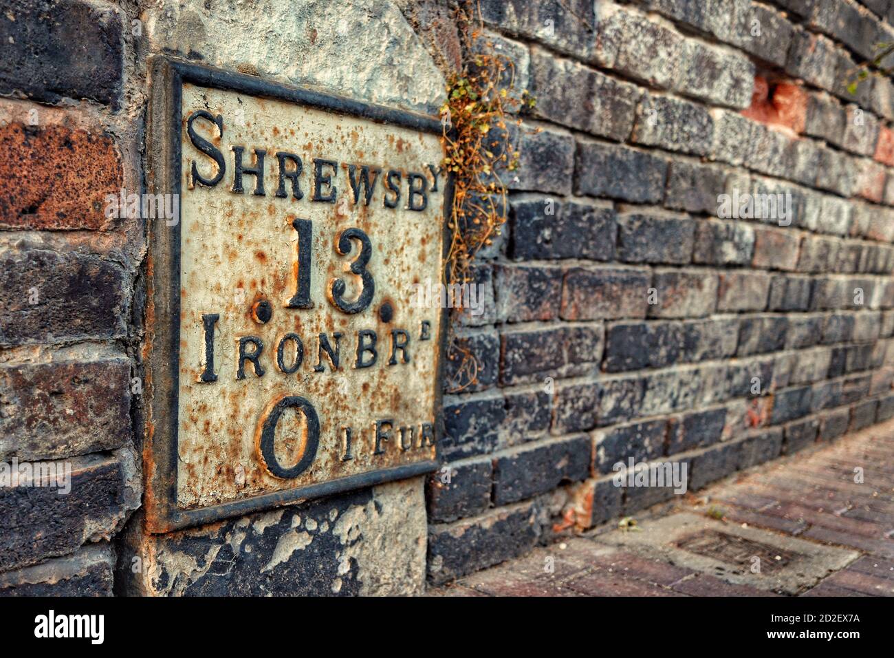 Cast iron waymarker in Ironbridge, Shropshire, showing 13 miles to Shrewsbury and 1 furlong to Ironbridge Stock Photo