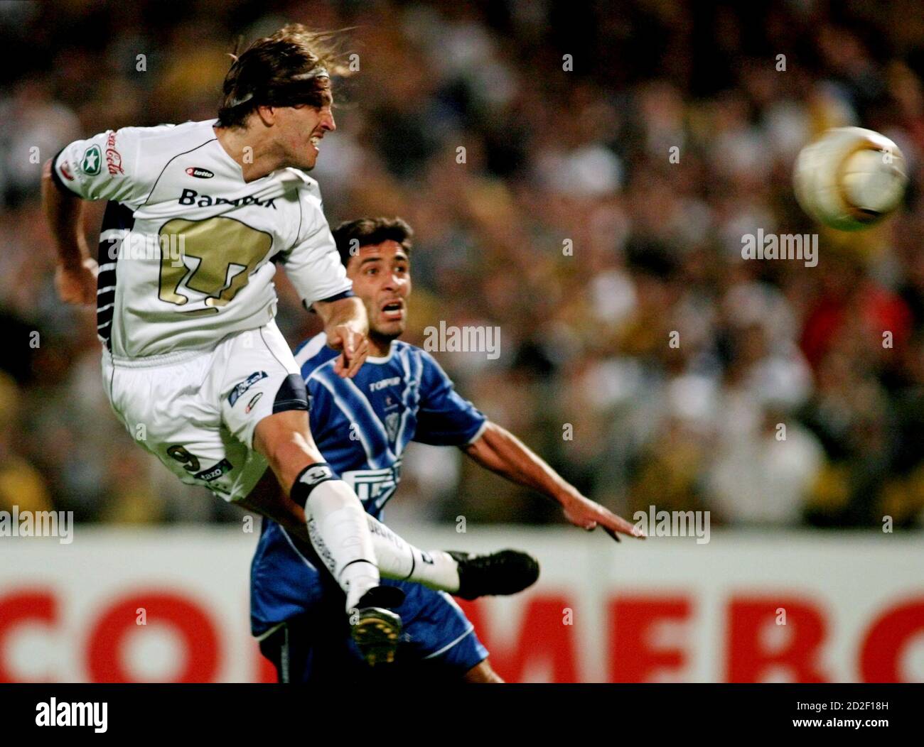 Pumas' Bruno Marioni (L) scores his hat trick as Leandro Gracian of Velez  Sarsfield looks on during the second leg of their Copa Sudamericana soccer  semi-final at the University Stadium in Mexico