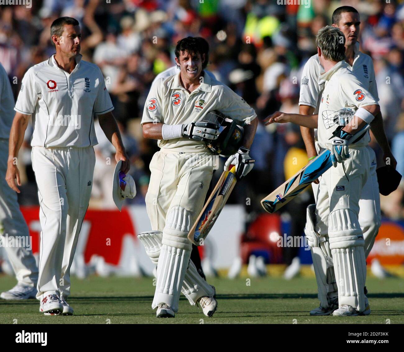 Australia's Michael Hussey (2nd L) walks off the ground with team mate  Michael Clark (2nd R) as England players Ashley Giles (L) and Kevin  Pietersen walk away after Australia won the second