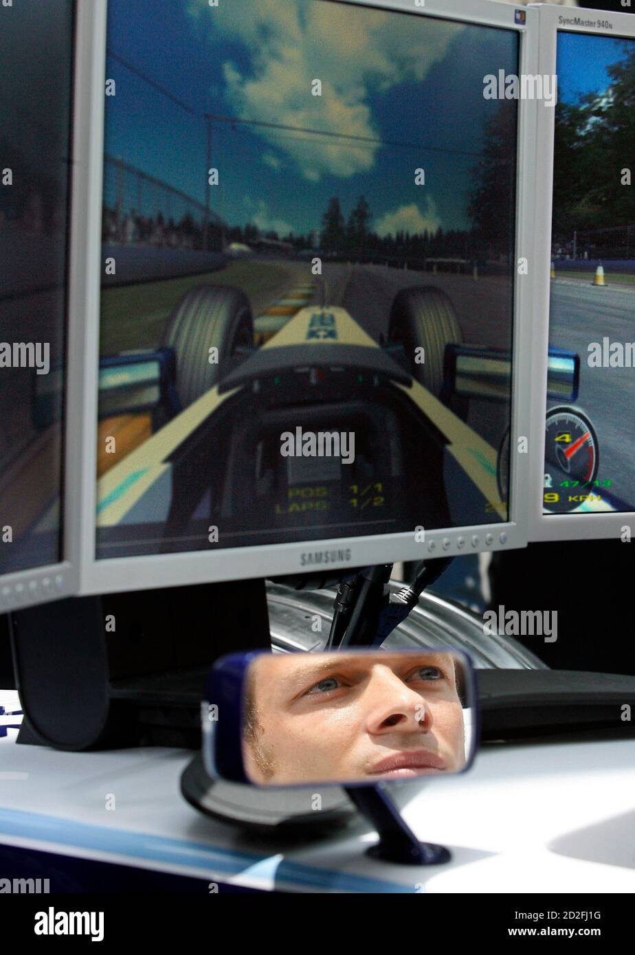 Williams Formula One (F1) driver Alex Wurz of Austria uses a F1 simulator in a model of a full-size Williams car during the Grand Prix Challenge in Singapore April 4, 2007.  Singapore is the second city in the world to hose the Grand Prix Challenge, in which members of the public compete on a simulator to attain the best lap times on a simulated circuit. Three top participants from Singapore competed against Williams F1 drivers Narain Karthikeyan and Wurz during the grand finals on Wednesday.  REUTERS/Nicky Loh (SINGAPORE) Stock Photo