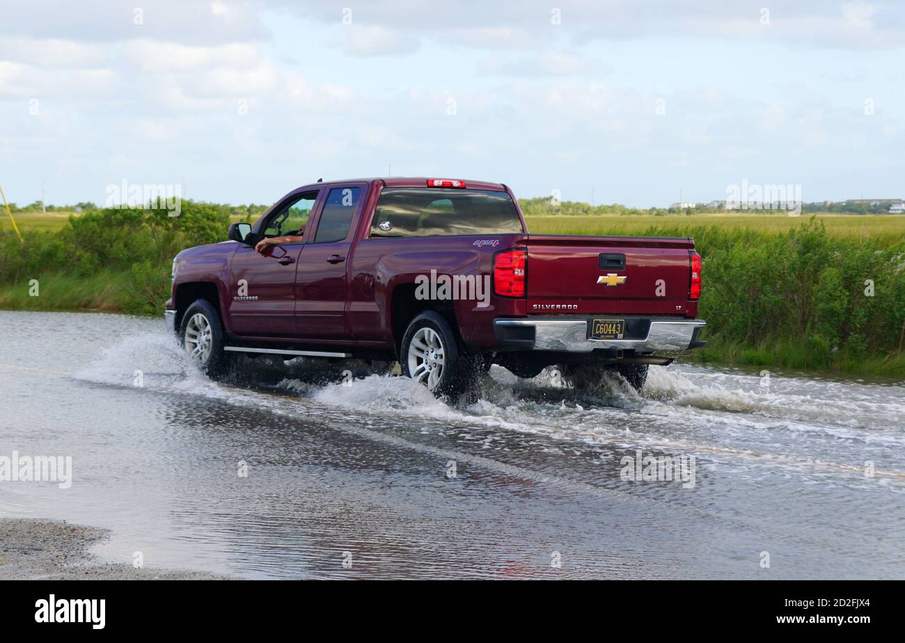 Bethany Beach, Delaware, U.S.A - October 1, 2020 - A red Chevy Silverado truck passing the flooded road Stock Photo