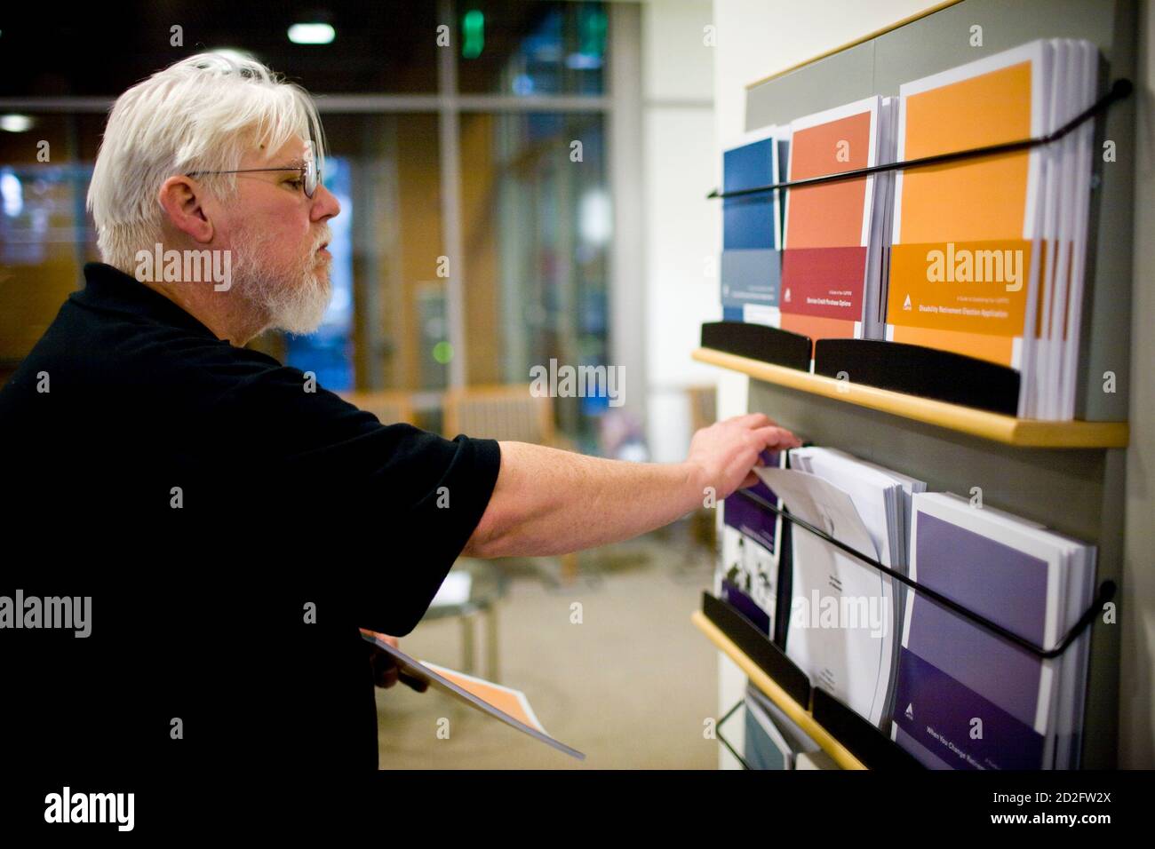 California state worker Curtis Walker looks over retirement plan brochures at the Calpers regional office in Sacramento, California October 21, 2009. Calpers, the largest U.S. public pension fund, manages retirement benefits for more than 1.6 million people, with assets comparable in value to the entire GDP of Israel. The Calpers investment portfolio had a historic drop in value, going from a peak of $250 billion in the fall of 2007 to $167 billion in March 2009, a loss of about a third during that period. It is now around $200 billion. REUTERS/Max Whittaker (UNITED STATES BUSINESS) Stock Photo