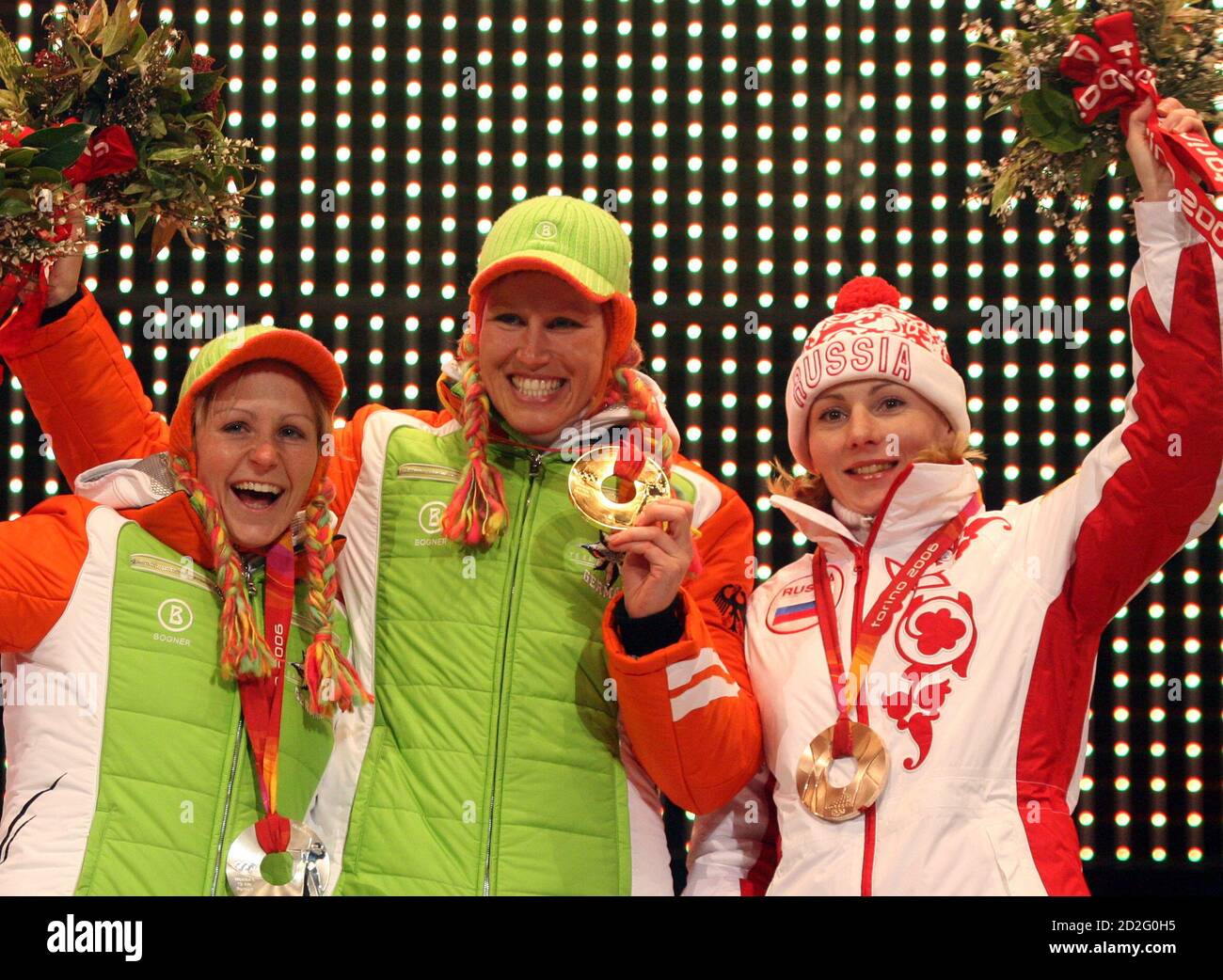Gold medallist Kati Wilhelm (C) of Germany, silver medallist Martina Glagow  (L) of Germany and bronze medallist Albina Akhatova of Russia celebrate  after receiving their medals for the biathlon women's 10 km