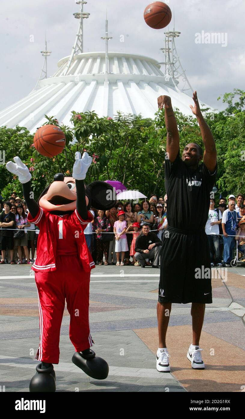 NBA basketball player Kobe Bryant (R) shoots with Mickey Mouse at the
